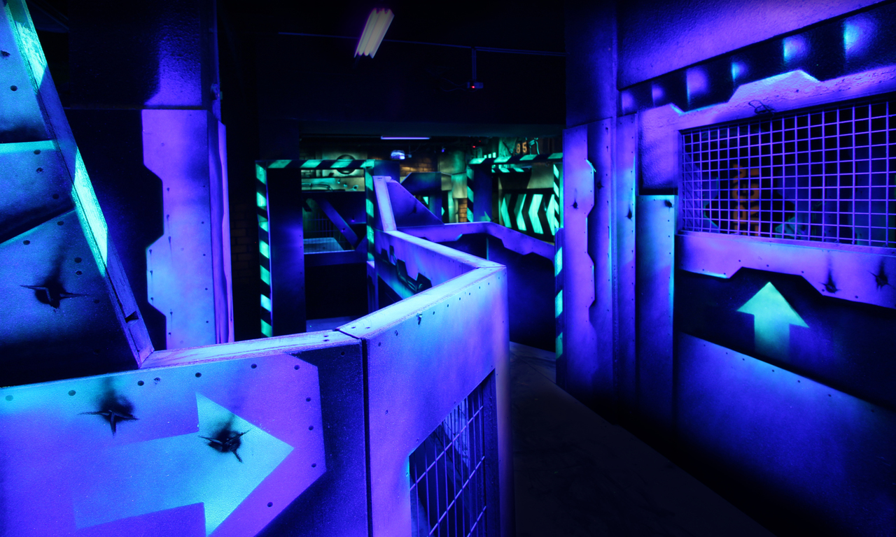 Le labyrinthe du laser game en lumière noire, cloisons fluo et flèches · Photo Office de tourisme de Lyon