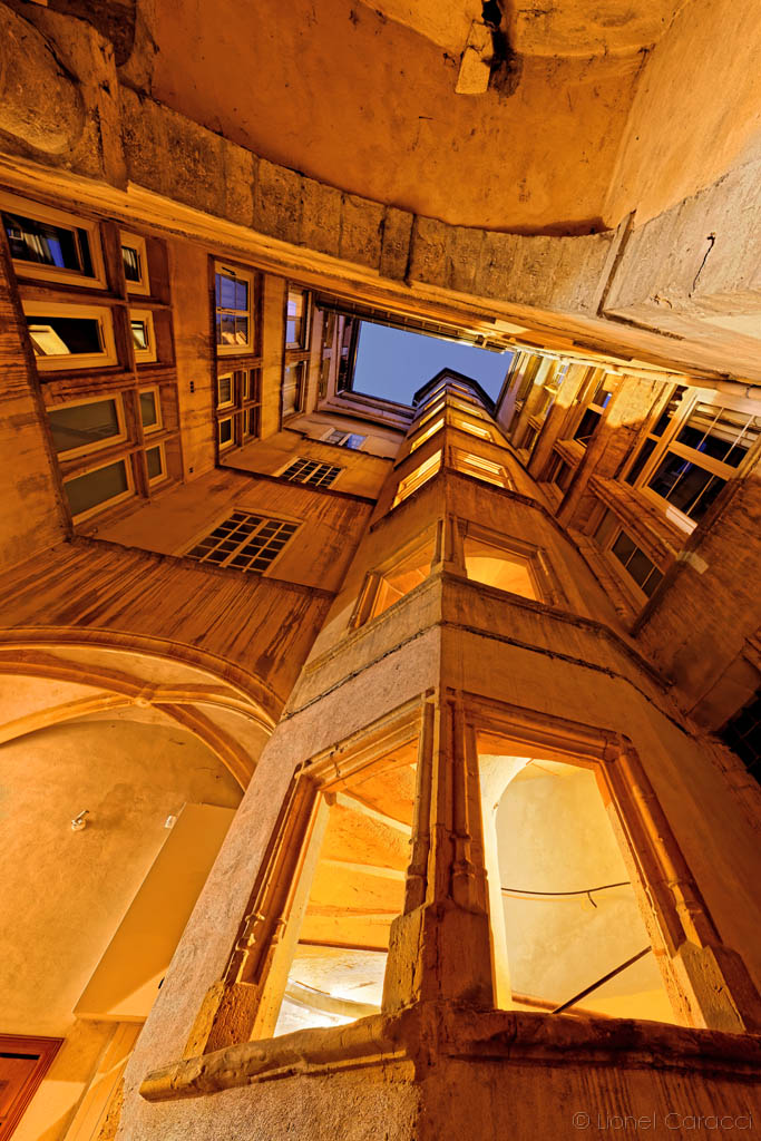 L'escalier à vis d'une cour lyonnaise, vu d'en bas · Photo diffusée par Krom Galerie