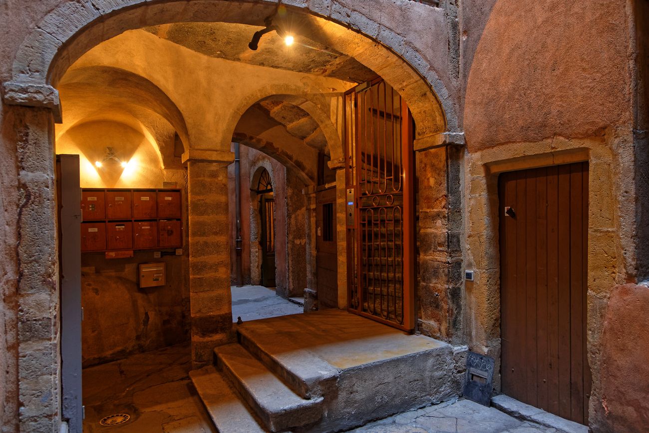 L'intérieur d'une traboule du Vieux Lyon, son passage voûté et ses boîtes aux lettres · Photo diffusée par Visite Lyon